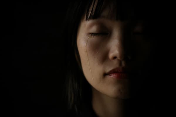 静かに涙を流す女性のクローズアップ写真。心の痛みや悲しみを表現